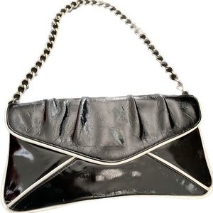 Chain strap clutch/purse. Black with white piping at seams. Measures 12”x6”x1/2”